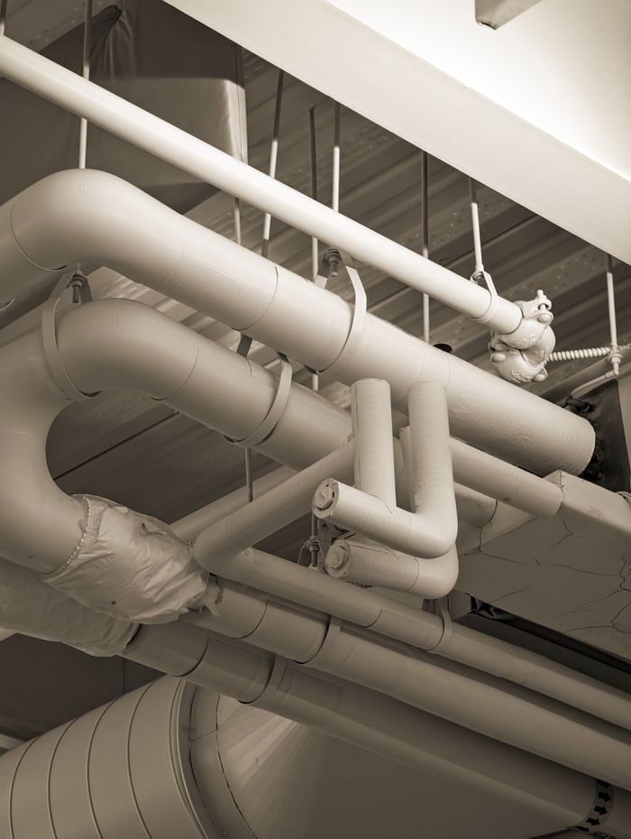 Crafting Captivating Headlines: Your awesome post title goes here Complex network of industrial pipes and ducts in a sepia-toned indoor setting.