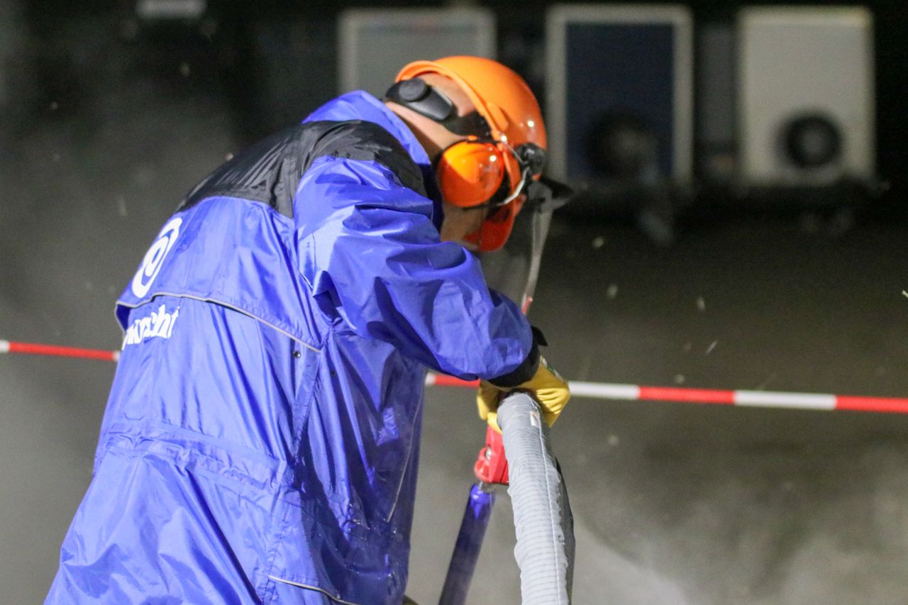The Art of Drawing Readers In: Your attractive post title goes here Industrial worker in protective gear using equipment, emphasizing safety in construction.